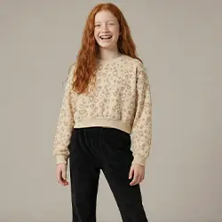 Dívka v béžovém svetru a černých kalhotách před světlým pozadím. Dívka v béžovém svetru a černých kalhotách před světlým pozadím.